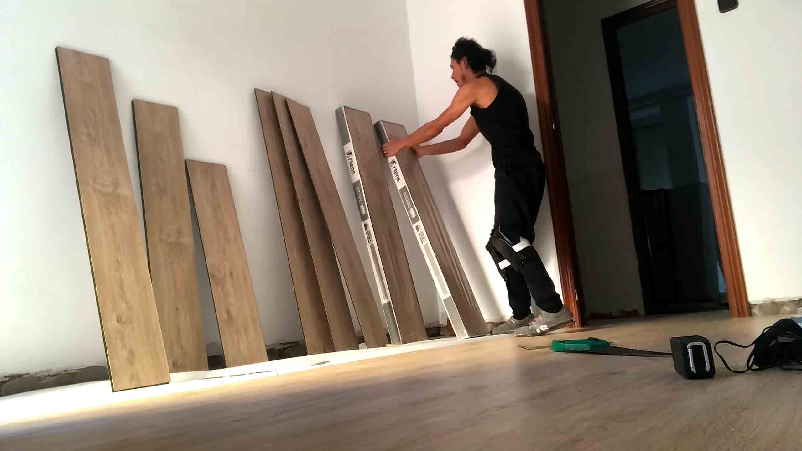 Laminate hardwood floor installation process, including subfloor preparation, underlayment, and click-lock plank system. Services offered: full installation, partial installation, consultation, and repair