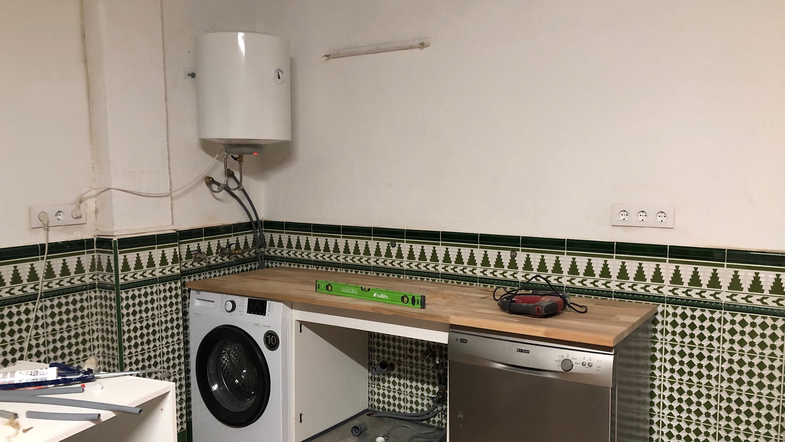 Technician installing a water heater in a residential setting, demonstrating the process of connecting pipes and wiring