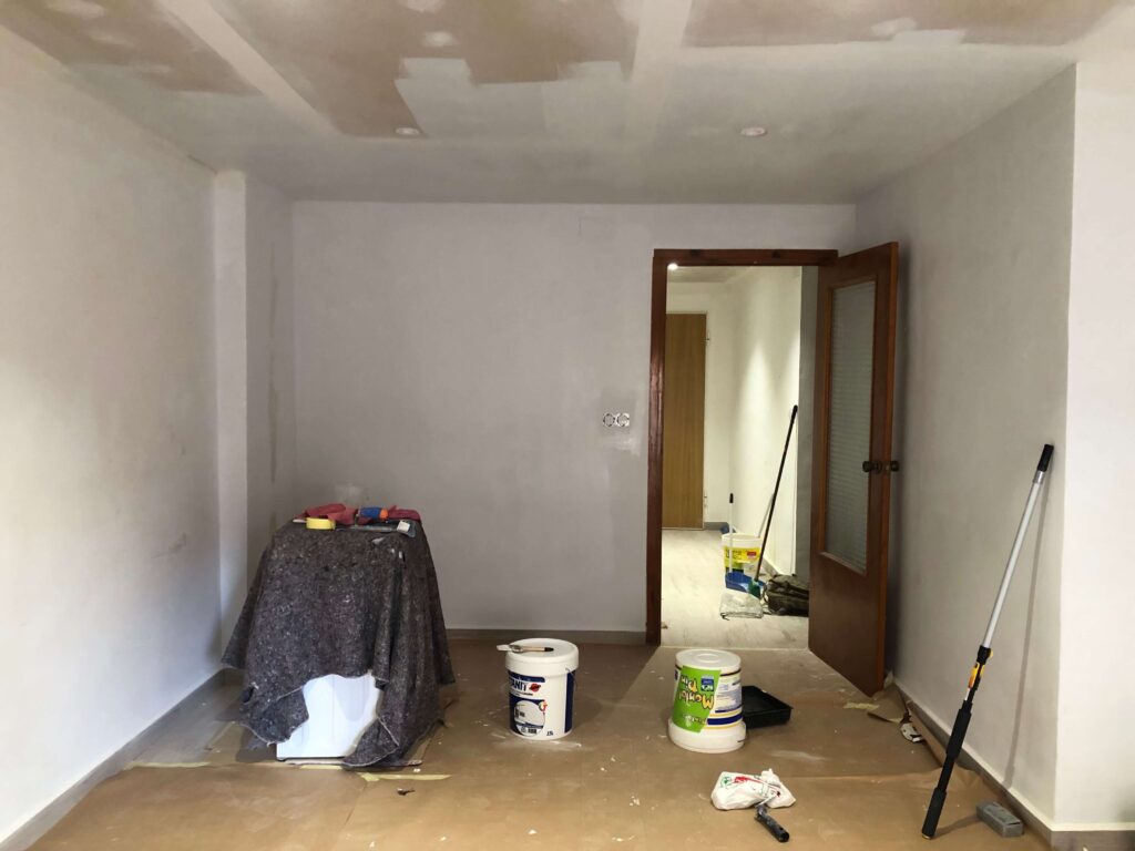 Image of ceiling being painted:
"A roller applying white paint to the ceiling, brightening the room and covering up dark patches from previous wear."