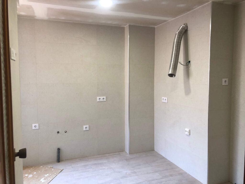 Image of a flat prepped and ready for painting:
"Flat prepped for painting with walls patched and smoothed, painter's tape applied along the edges and trim, and furniture covered with protective sheets, ensuring a clean and organized workspace."